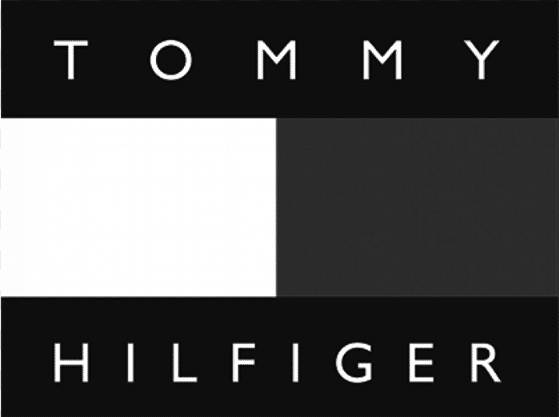 Logo Tommy Hilfiger monochrome en noir et blanc. Il présente le nom "TOMMY" en haut et "HILFIGER" en bas, encadrant un drapeau bicolore.
