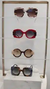 Quatre paires de lunettes de soleil tendance exposées: écaille blanc/marron, rondes rouges, rondes écaille clair et carrées écaille bleu.